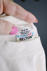 Women's or men's vintage 1990's Tough Tee, Belton, Made in USA label short sleeve white graphic t-shirt with ribbed neck in cotton material.