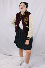 Women's or men's vintage 1982 Nelson's Jackets, Portland, Oregon label long sleeve letterman jacket with a maroon wool body and cream colored leather arms. Yellow stripped trim and popper buttons. Embroidery on chest.