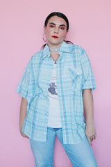 Men's vintage 1980's Levi's label short sleeve button up shirt in plaid print. Blue, white, yellow, green, and burnt orange. Lightweight Cotton materials.