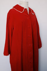 Women's vintage 1960's long length long sleeved red velvet robe duster with a peter pan collar and pink stain trim. Buttons up the front.