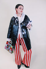 Women's vintage 1960's long sleeve black vinyl material jacket with gold buttons and hardware. Fully lined and has two side pockets.