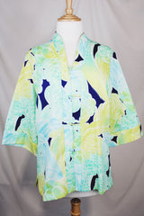 Women's vintage 1970's long sleeve button up tunic blouse with all over green and navy floral print. Flared sleeved and fabric covered buttons.