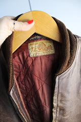 Men's or women's vintage 1950's Genuine Horsehides All Weather Garment, San Francisco, California label long sleeve brown leather bomber jacket with ribbed knit trim and quilted liner.