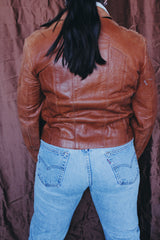Women's or men's vintage 1970's Wilson label long sleeve burnt orange colored leather zip up jacket. Side pockets and dagger collar.