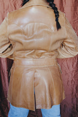 Women's or men's vintage 1970's Lou Pollack, Made in Spain label long sleeve long length tan camel brown colored leather blazer jacket with tortoise buttons up the front.