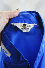 Women's or men's vintage 1970's Zody's Quality Plus, Made in Japan label long sleeve bright blue nylon zip up windbreaker with white and red trim.