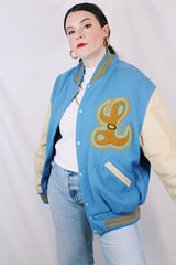Men's or women's vintage 1994 Settlemien's, Portland, Oregon label long sleeve baby blue and cream varsity letterman jacket with yellow trim in leather and wool material.