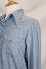 Men's vintage 1970's long sleeve chambray denim shirt with colored embroidery in the front and back.
