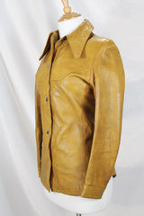 Women's vintage 1970's Made in Belgium label long sleeve light tan colored leather lightweight jacket with silver snap buttons and a dagger collar.