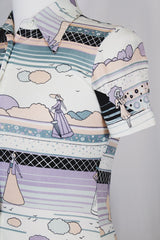 Women's vinttage 1970's Fritz label short sleeve button up blouse with dagger collar and all white, blue, and purple novelty print in a lightweight polyester material.