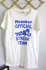 Women's or men's vintage 1970's Hanes short sleeve white t-shirt with blue lettering on the front. Ribbed neckline, long length, and 100% cotton material.