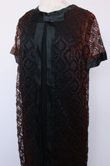 Women's vintage 1960's short sleeve mini length black dress with lace overlay and ribbon trim and bow. Zipper in the back.