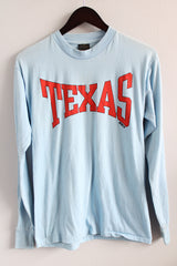 Men's or women's vintage 1980's Touch of Gold, Made in USA label long sleeve light blue t-shirt with red text on front that reads Texas in a polyester and cotton material.