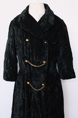 Women's vintage 1960's Raymodes, NY label long length long sleeve black velvet duster coat. Bronze buttons with bronze chains.