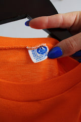 Women's or men's vintage 1970's Artex, Made in USA label long sleeve bright orange t-shirt with white text and graphic on front in cotton material.