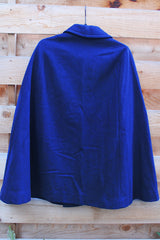 Women's vintage 1960's navy blue wool material poncho with slits for arms, gold hardware and gold buttons. Fully lined.