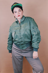 Men's vintage 1980's Flyer's CWU Military Flyer's Jacket, Made in USA label size medium long sleeve cropped length army green zip up bomber jacket with orange liner.