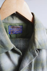Men's vintage 1960's Pendleton size medium long sleeve button up wool shirt in all over green and white plaid print. Two chest pockets.