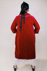 Women's vintage 1960's long length long sleeved red velvet robe duster with a peter pan collar and pink stain trim. Buttons up the front.