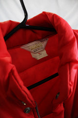Women's or men's vintage 1980's Tonkin Wearables, Woodinville, WA, Made in USA label long sleeve bright red nylon puffer jacker with patch on left chest and a zipper and popper buttons closure.