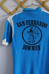 Women's or men's vintage 1960's Hilton, Made in USA label short sleeve blue and white half closure polo t-shirt with black graphic on the back.