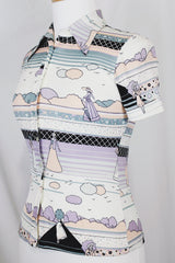 Women's vinttage 1970's Fritz label short sleeve button up blouse with dagger collar and all white, blue, and purple novelty print in a lightweight polyester material.