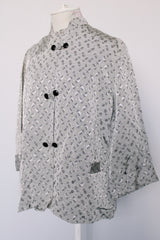 Women's vintage 1960's The Original Stork-A-Lure label long sleeve grey stain jacket with all over print. Black buttons up the front and mandarin collar.