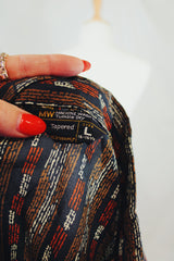 Men's or women's vintage 1970's Montgomery Ward, JCPenney label long sleeve button up shirt in lightweight polyester material. Black with tan and orange vertical stripe pattern.