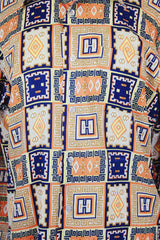 Men's vintage 1970's Envoy label long sleeve button up shirt with dagger collar with all over orange and navy abstract print.