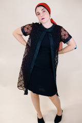 Women's vintage 1960's short sleeve mini length black dress with lace overlay and ribbon trim and bow. Zipper in the back.