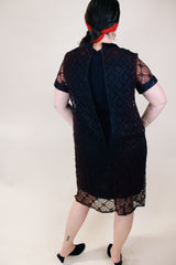Women's vintage 1960's short sleeve mini length black dress with lace overlay and ribbon trim and bow. Zipper in the back.