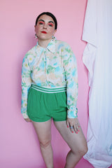 Women's vintage 1970's long sleeve button up blouse with collar in an overall yellow, green, and blue floral print. Acetate and Nylon blend material.