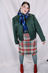 Women's or men's vintage cropped army jacket in a dark green grey wool material. Has a button closure and two front chest pockets.