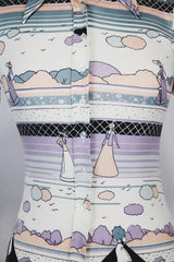 Women's vinttage 1970's Fritz label short sleeve button up blouse with dagger collar and all white, blue, and purple novelty print in a lightweight polyester material.