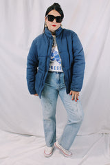 Men's or women's vintage 1980's long sleeve navy blue puffer jacket with zipper, popper buttons, and pockets. Cotton and polyester materials.