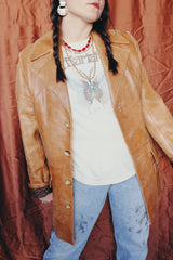 Women's or men's vintage 1970's Lou Pollack, Made in Spain label long sleeve long length tan camel brown colored leather blazer jacket with tortoise buttons up the front.