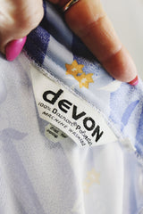 Women's vintage 1970's Devon long sleeve button up blouse with a dagger collar. Light purple color with all over ditsy floral print.