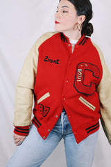 Men's vintage 1987 Nelson's Jackets, Portland, Oregon label long sleeve cream and red colored varsity letterman jacket in wool and nylon material. Has patches and pins.