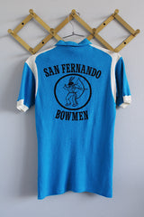 Women's or men's vintage 1960's Hilton, Made in USA label short sleeve blue and white half closure polo t-shirt with black graphic on the back.