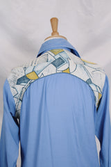 Men's vintage 1970's long sleeve button up blue colored shirt with patchwork detail throughout. Pearl snapper buttons up the front.