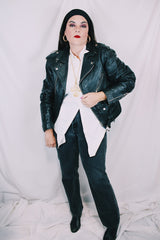 Men's or women's vintage 1980's long sleeve black leather motorcycle jacket with silver hardware. Zipper front closure and pockets.