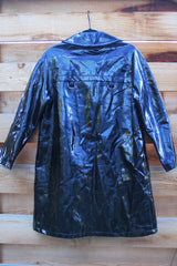 Women's vintage 1960's long sleeve black vinyl material jacket with gold buttons and hardware. Fully lined and has two side pockets.