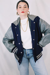 Men's or women's vintage 1980's Settlemein's, Portland, Oregon label long sleeve navy and grey varsity letterman jacket in wool, leather, and nylon. Snap buttons and hood.