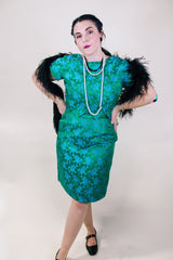 Women's vintage 1960's short sleeve midi length green and blue stain dress. Subtle floral print and scalloped waist. Zipper in the back.