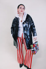 Women's vintage 1960's long sleeve black vinyl material jacket with gold buttons and hardware. Fully lined and has two side pockets.