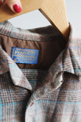 Men's vintage 1960's Pendleton size large long sleeve button up wool shirt in all over brown and blue plaid print. Two chest pockets.