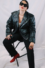 Men's vintage 1980's black genuine leather zip up motorcycle style jacket. All over silver hardware, popper buttons, and and zippers.