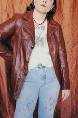 Women's or men's vintage 1970's chocolate brown colored leather jacket with leather buttons and double lapel.