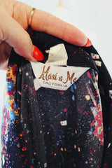 Men's vintage 1970's Maxi & Me California label long sleeve black slinky polyester material button up shirt with all over multi colored paint splatter print.