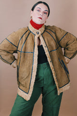 Women's vintage 1970's size medium long sleeve tan brown suede jacket with one button closure, cream fur trim, and black trim throughout.